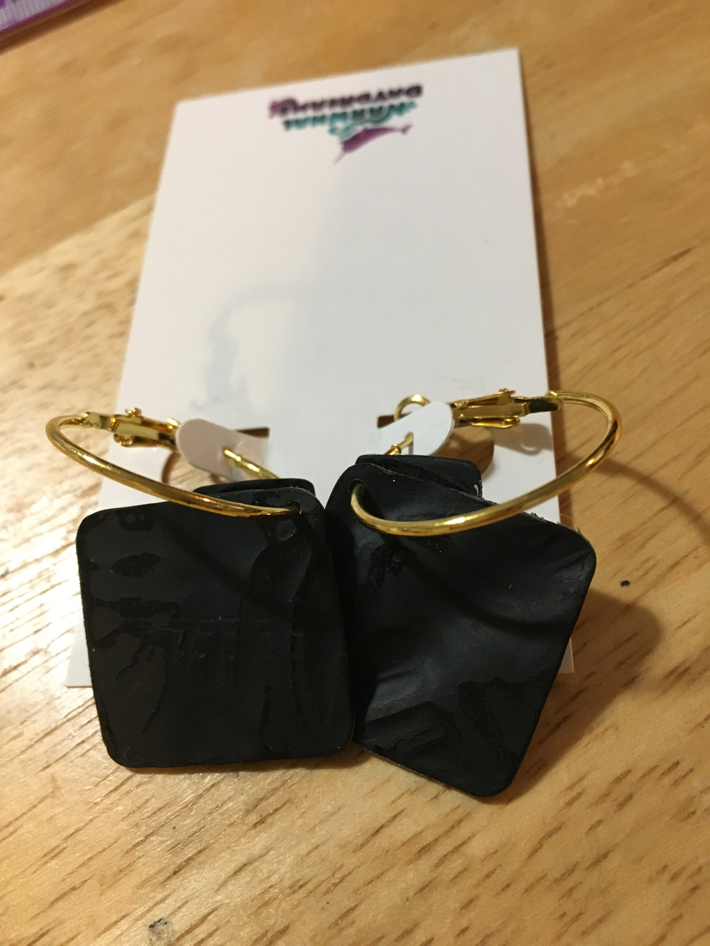 Textured dark gray squares on gold hoop earrings